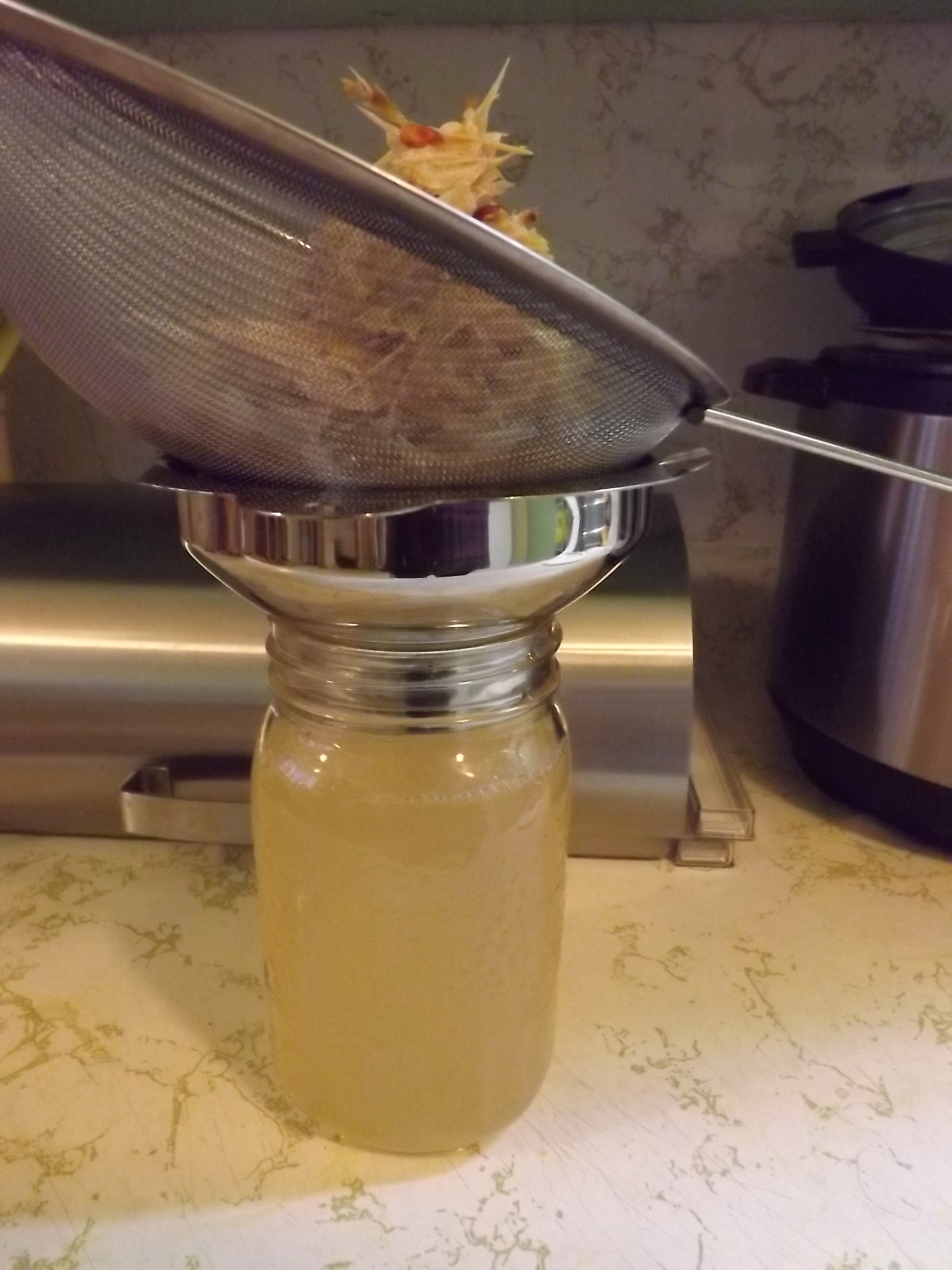 sieve of apple mash draining on coffee filter