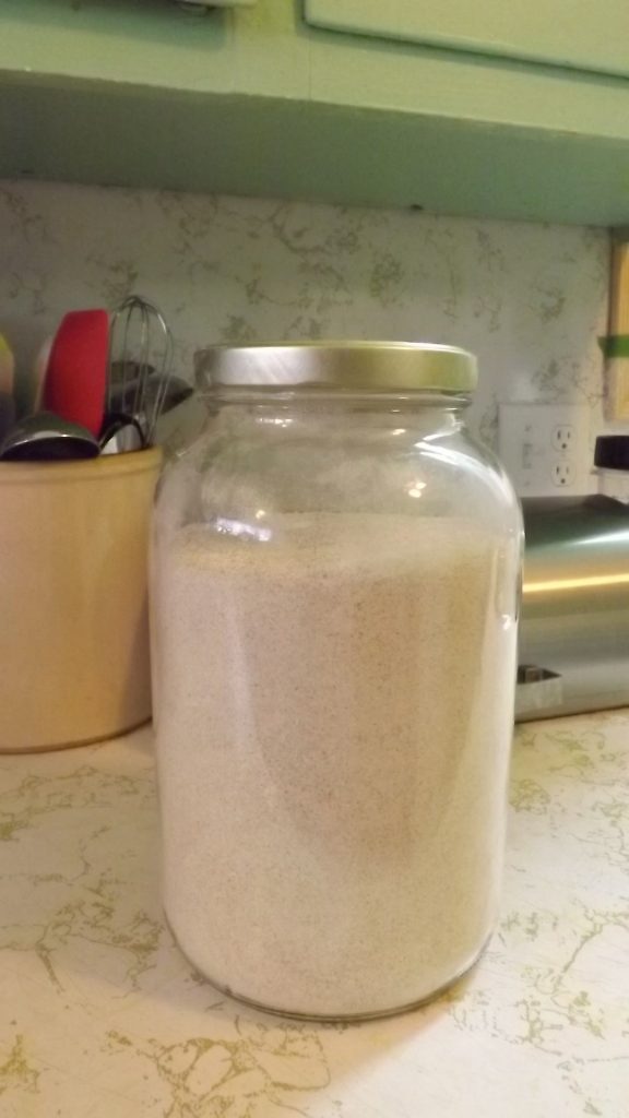 Gallon jar almost full of whole wheat flour.