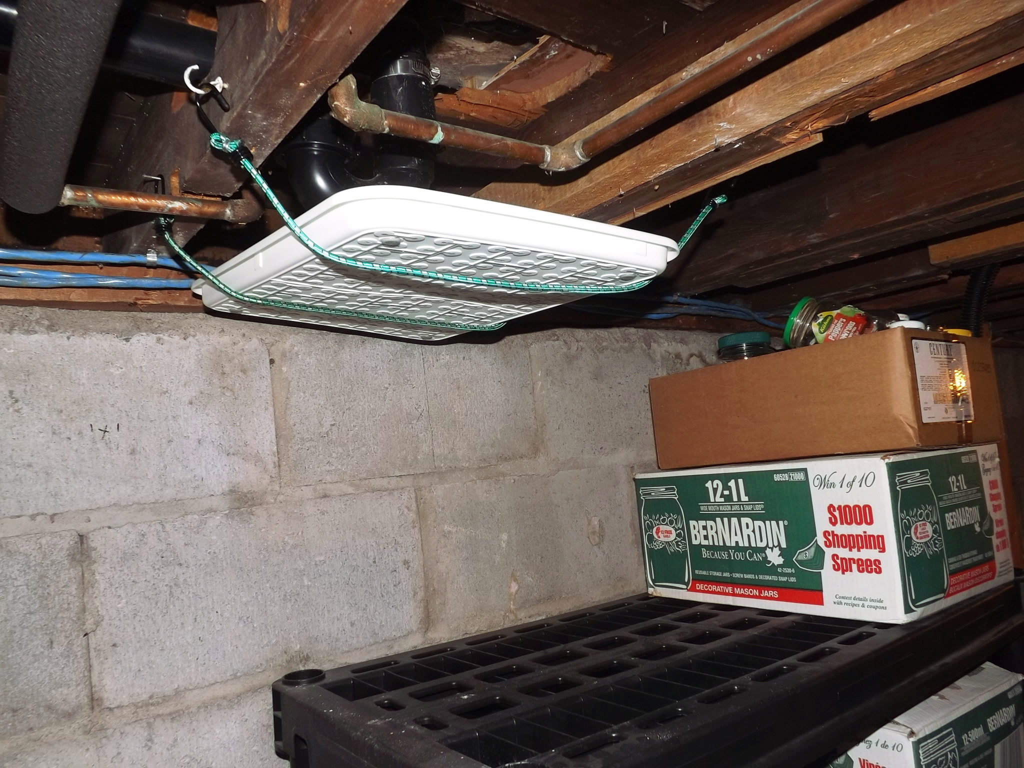 aa plastic tray suspended from the floor joists under the bathtub