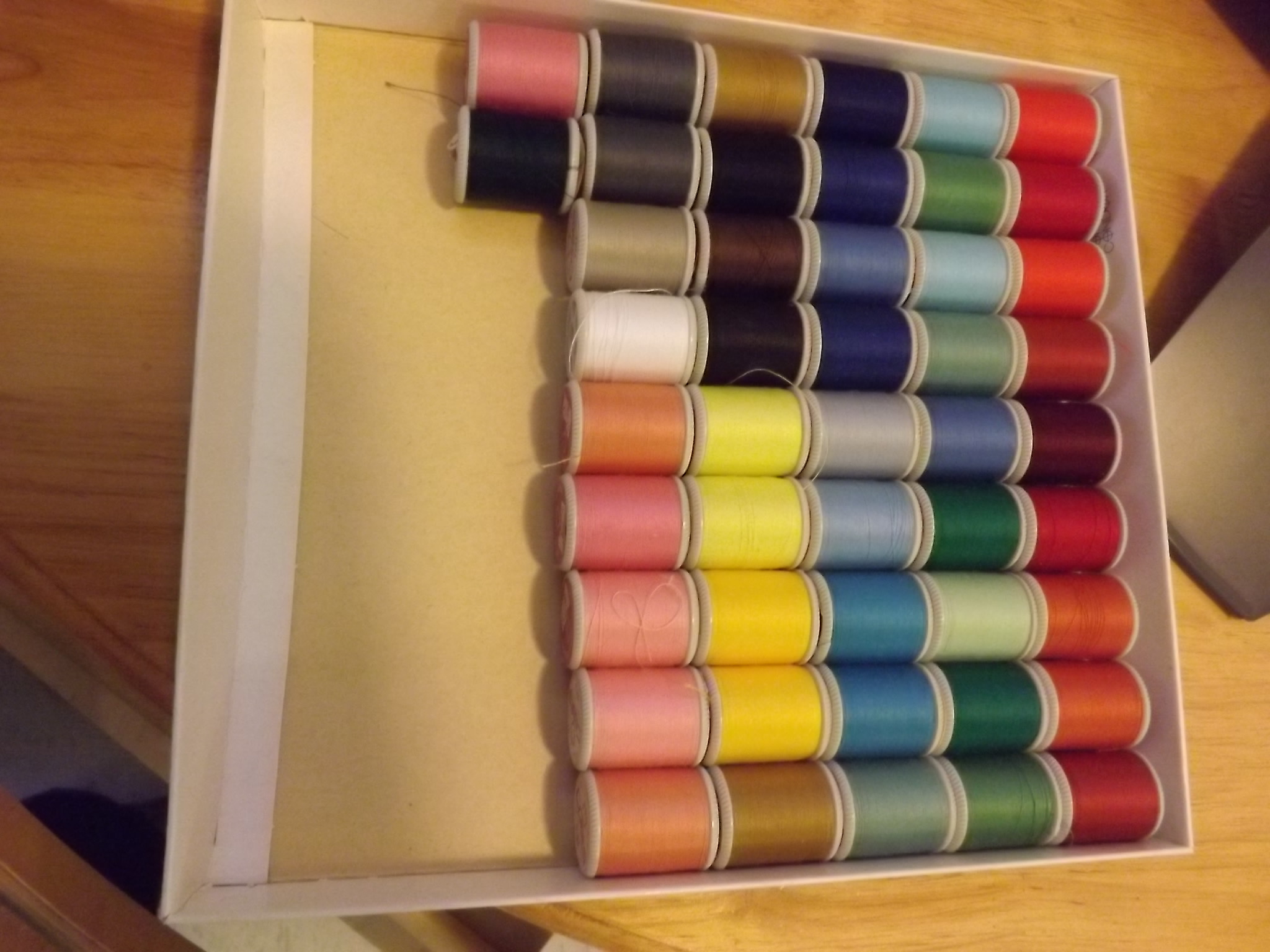 spools of different coloured thread in a box